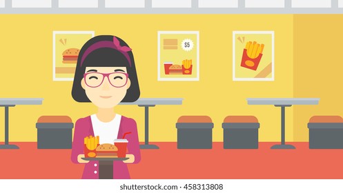 An asian woman holding tray full of junk food on a cafe background. Smiling woman in fast food restaurant. Woman having lunch in fast food restaurant. Vector flat design illustration. Horizontal