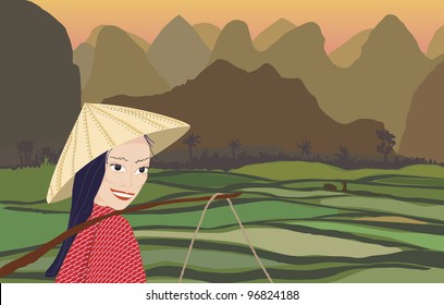 Asian woman smiling while working in rice fields at sunset with mountains behind
