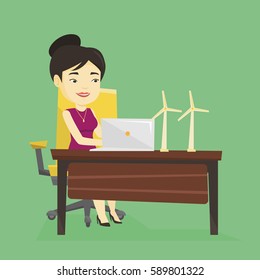 Asian worker of wind farm working on a laptop. Young engineer projecting wind turbine in office. Smiling engineer with model of wind turbine. Vector flat design illustration. Square layout.
