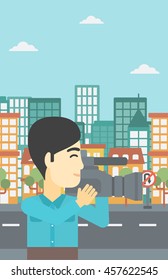 An asian young cameraman looking through movie camera. Man with professional video camera in the city. Cameraman shooting outdoor. Vector flat design illustration. Vertical layout.
