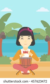 An asian young woman playing ethnic drum. Mucisian playing ethnic drum on the tropical beach. Woman playing ethnic music on tom-tom. Vector flat design illustration. Vertical layout.