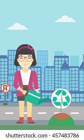 An asian young woman watering a tree with a recycle sign instead of crown on a city backround. Eco-friendly woman takes care of the environment. Vector flat design illustration. Vertical layout.