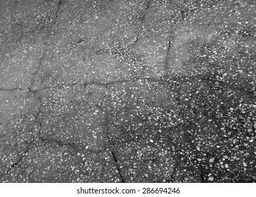 Asphalt cracked road dark texture.