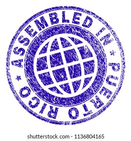 ASSEMBLED IN PUERTO RICO stamp watermark with distress texture. Blue vector rubber print of ASSEMBLED IN PUERTO RICO caption with retro texture. Seal has words arranged by circle and planet symbol.