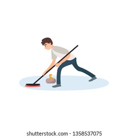 An athlete in gray clothes on the ice is rubbing the floor with a brush, thus pushing a stone.