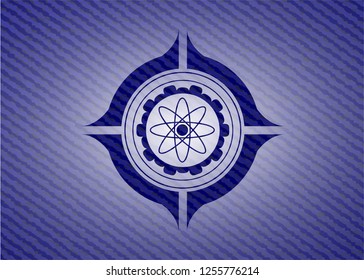 atom icon inside badge with denim texture