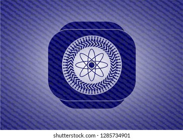 atom icon inside badge with denim background