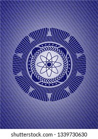 atom icon inside badge with denim background