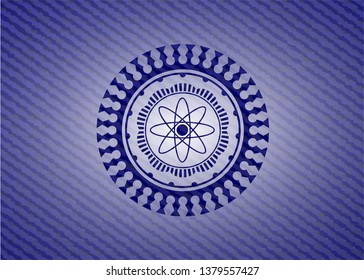 atom icon inside badge with denim background
