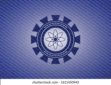 atom icon inside badge with denim texture