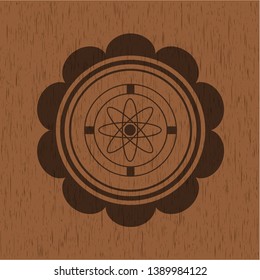 atom icon inside badge with wooden background