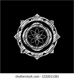atom icon inside chalkboard emblem written on a blackboard