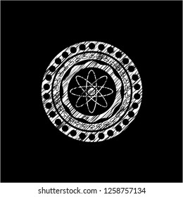 atom icon inside chalkboard emblem written on a blackboard