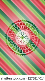 atom icon inside christmas colors badge.