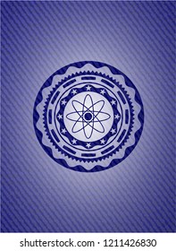 atom icon inside denim background