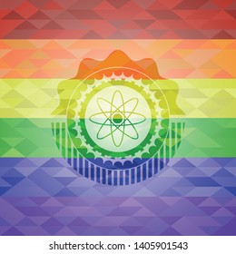 atom icon inside emblem on mosaic background with the colors of the LGBT flag