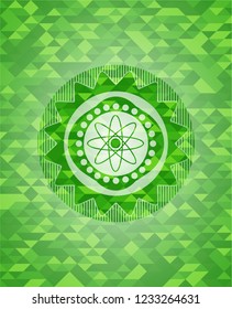 atom icon inside green emblem with mosaic background