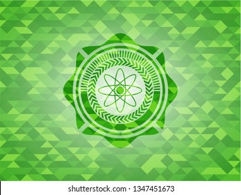 atom icon inside green emblem. Mosaic background