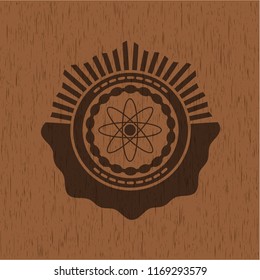 atom icon inside realistic wood emblem