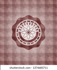 atom icon inside red seamless emblem or badge with abstract geometric pattern background.