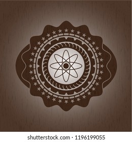 atom icon inside wooden emblem