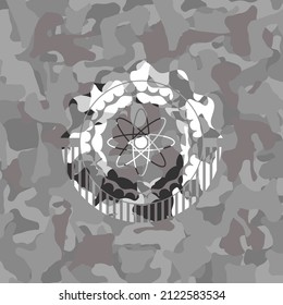 ícono de átomo sobre textura camuflada gris. 