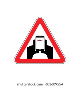 Attention Vertical video. Hand and smartphone to record. Road sign on red triangle. symbol Caution
