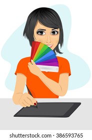 attractive female asian graphic designer showing pantone color chart palette while working with graphics tablet