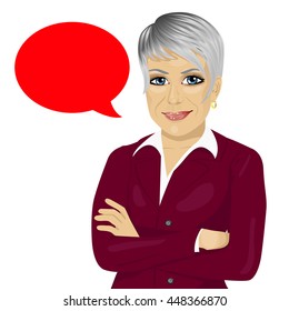 attractive senior businesswoman with arms folded standing near red blank speech bubble