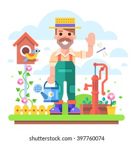 Attractive young gardener with a watering can in overalls stands in a garden on a background of flowers and shrubs near the old water pump. 
Modern vector character in flat design.