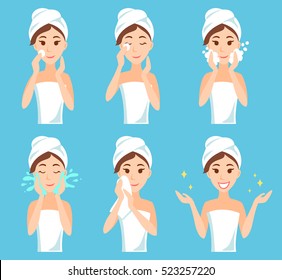 Attractive young woman with a towel around her head and body remove make-up, clean, wash and care her face with sponge. Facial treatment procedures.