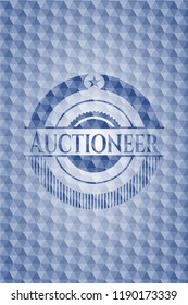 Auctioneer blue badge with geometric pattern.