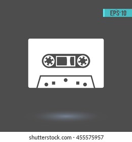 Audio cassette vector icon. Graphic symbol for web design, logo. White glyph on a gray background. Isolated sign.