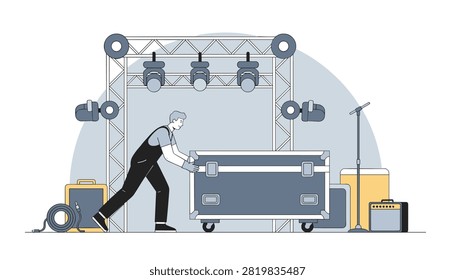 Audio technician pushing a large flight case on wheels across a stage with lighting truss and speakers.