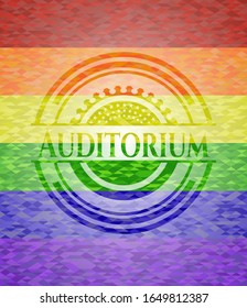 emblema del auditorio sobre fondo de mosaico con los colores de la bandera LGBT