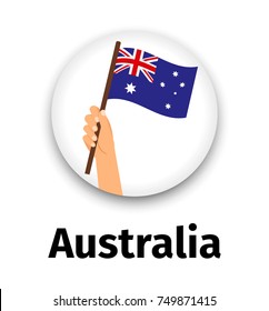 Australia flag in hand, round icon with shadow isolated on white. Human hand holding flag, vector illustration