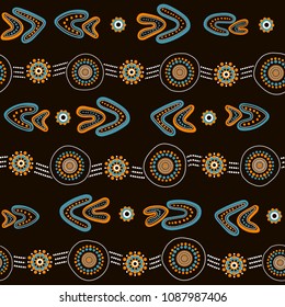 Australian aboriginal seamless vector pattern with colorful dotted circles, rings, boomerang and wavy stripes on dark brown background