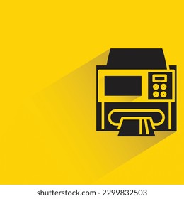 automated teller machine with shadow on yellow background