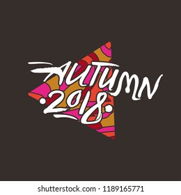 Autumn 2018. Calligraphic inscription against of a bright triangle. Art seasonal Autumn 2018 logo vector template on a dark background.