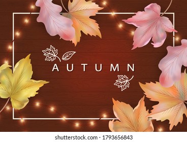 Autumn banner with a frame and fallen leaves on a wooden background