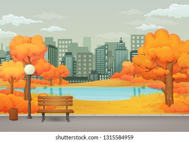 Autumn Day Park Scene. Bench With Trash Can And Street Lamp On A Park Trail With Trees And Bushes With Falling Leaves. Lake, Cityscape With Skyscrapers And Gray Sky With Clouds In The Background.