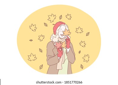 Autumn, fall, colourful fallen leaves concept. Young happy girl cartoon character in stylish casual clothing and beret enjoying leaf fall from maple tree in park or in forest alone in autumn 