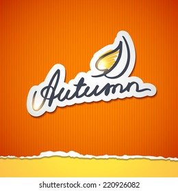 autumn, handwritten text with stylized leaf shape on ripped cardboard