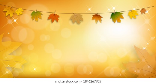 Autumn leaves hanging on a string with bokeh effect,Maple leaves in orange and red leaves on blurry bokeh background,Fall season concept with maple foliage on defocused sunlight effect with copy space