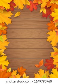 Autumn leaves on wooden background. Frame from fallen maple leaf. Template for a seasonal sale, invitation or advertisement card with empty space for text.