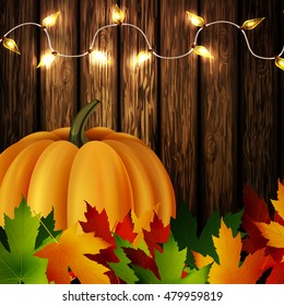 Autumn leaves and pumpkin on wooden texture