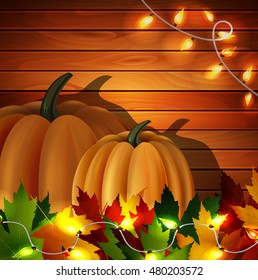 Autumn leaves and pumpkins on wooden texture