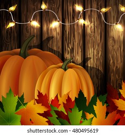 Autumn leaves and pumpkins on wooden texture