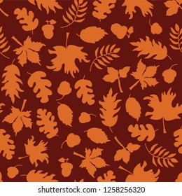 Autumn leaves seamless vector background. Orange leaf silhouettes on a red background. Acorns, oak tree, maple tree pattern. Doodle leaf print. Fall background, Thanksgiving, Seasonal print, November