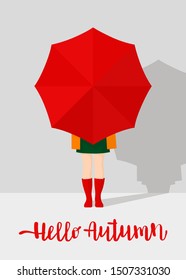 Autumn postcard. Girl in red rubber boots holding a red umbrella on grey background. Handwritten inscription "Hello Autumn"